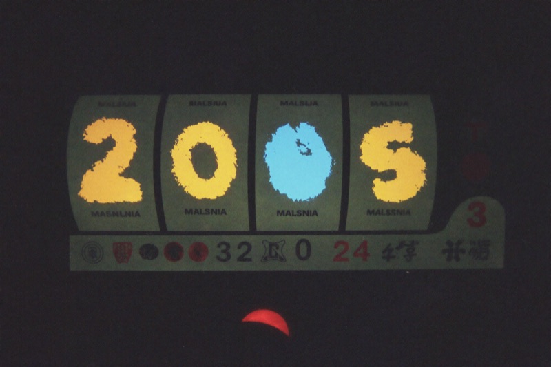 Close view of a slot game in portrait with the spin button under a thumb